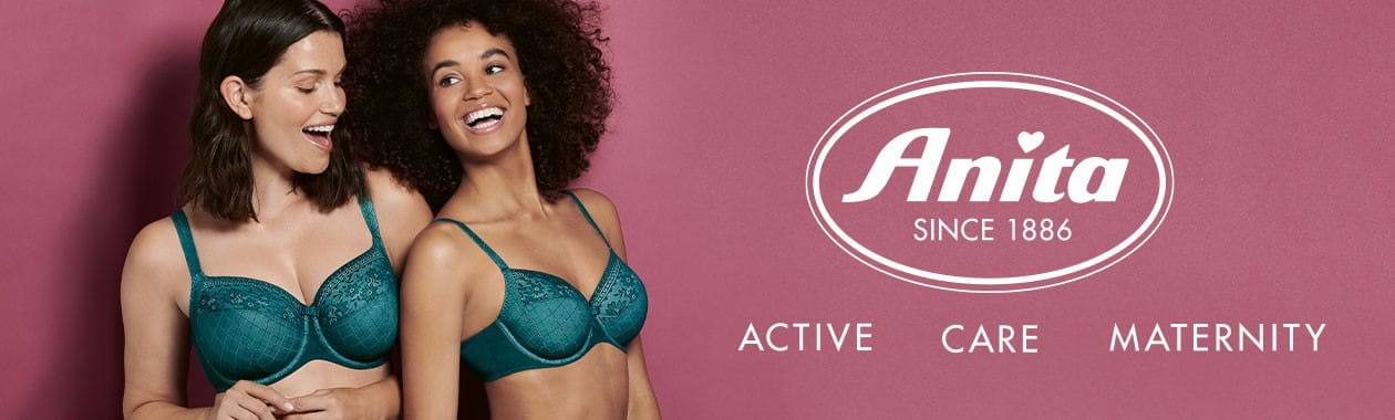 Zwei junge Frauen in jadefarbenen BHs von Anita, die neben dem Logo von Anita stehen